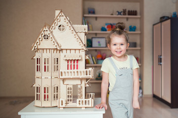 child playing and building wooden house 