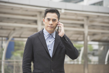 Handsome businessman asian talking on mobile phone.