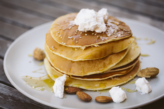 Image of some pancakes served on a plate on a wooden table.