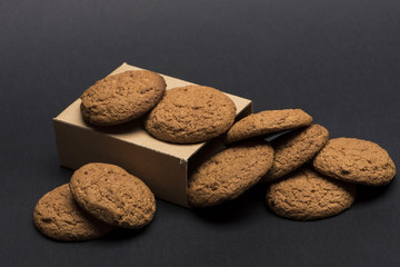 Cookies in carton box on dark grey background.