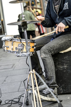 young white man/busker/drummer drumming in the street