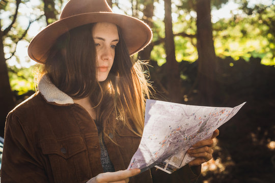 Young woman with map on forest