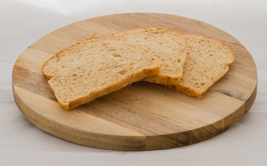Three slices of Crumbly healthy brown bread on a wooden cutting board