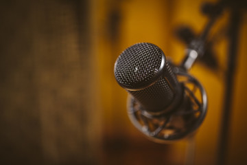Microphone in recording studio. Unfocused background.