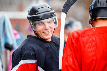 Smiling professional player waiting for substitution in ice hockey competition. Substitute ice...