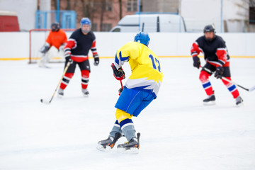 Unrecognizable ice hockey player with stick in attack. Ice hockey game on rink