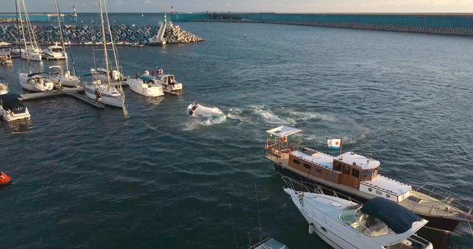 Man on a hydrocycle does stunts 360 in the bay. Aerial shot