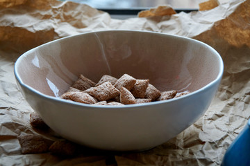 Dry breakfast is poured with milk into plates from a jug for milk