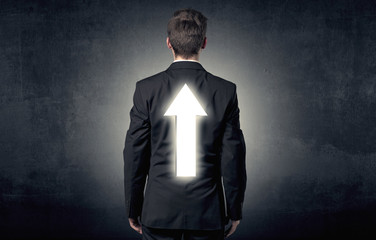 Young businessman standing with arrow on his back