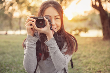 Happy young woman having fun with mirrorless camera travel photo of photographer Making pictures in hipster style