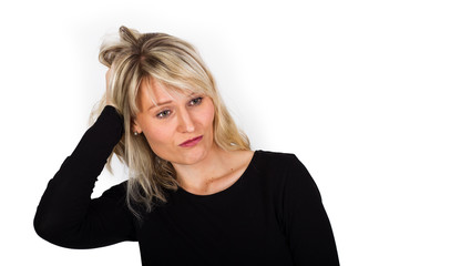 Unsichere blonde junge Frau kratzt sich am Kopf 