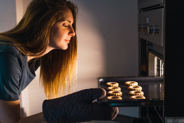 Woman making cookies in oven
