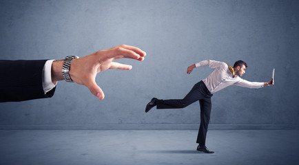 Businessman running from hand