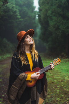 Charming woman with ukulele in nature