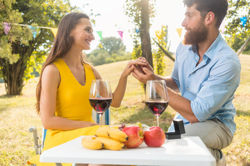 Frau und Mann trinken Wein bei einem romantischen Picknick im Sommer