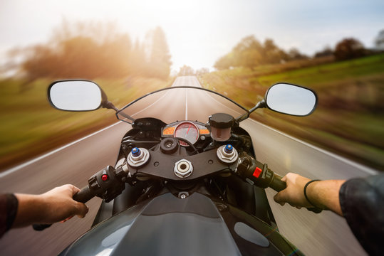POV shot of young man riding on a motorcycle. Hands of motorcyclist on a  street Stock Photo | Adobe Stock
