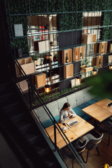 Young businesswoman with eyeglasses working on a computer in cafe. Business, online business concept.