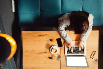 Top angle view of brunette businesswoman while working on a computer.