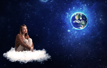Obraz na płótnie Canvas Woman sitting on cloud looking at planet earth