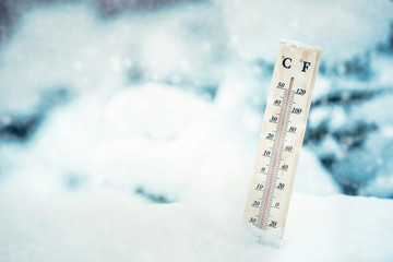 Falling snow in winter and a thermometer.