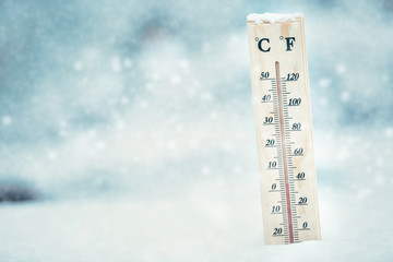 Falling snow in winter and a thermometer.