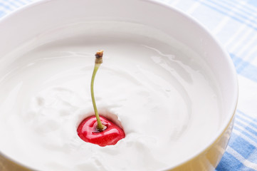 Cherry falling in the yogurt