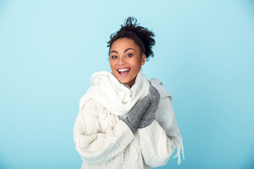 Young african woman isolated on blue wall studio winter concept laughing