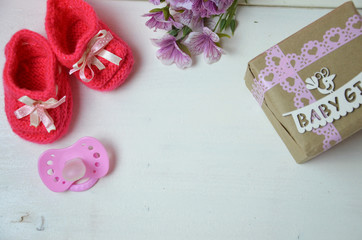 A newborn baby girl background. Newborn accessories for a baby girl on a pink wooden background.