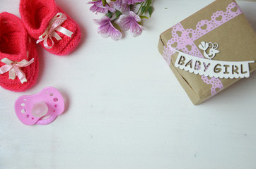 A newborn baby girl background. Newborn accessories for a baby girl on a pink wooden background.