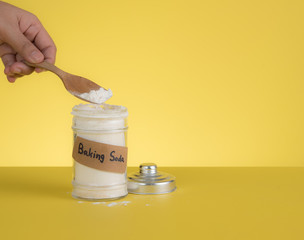 Jar of baking soda with text space against yellow background