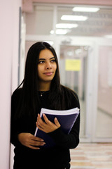 Student girl holding her notes in the university campus.