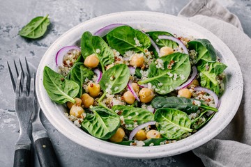 Healthy green salad bowl with spinach, quinoa, chickpeas and red onions