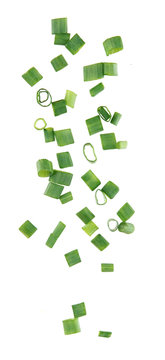 Flying pieces of chopped green onion on white background
