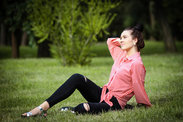 Fototapeta premium Beautiful girl sits on lawn