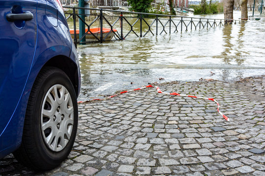 During the winter flood of the Seine in Paris, in January 2018, the level of the floodwater reaches the rear wheels of a car parked in a small sloping street leading down to the river.