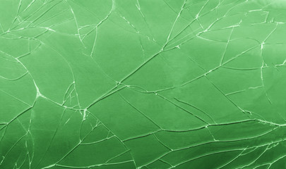 Top view cracked broken green glass texture background.