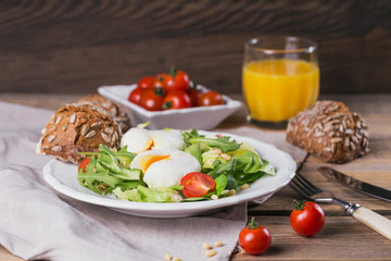Poached egg with green salad, tomatoes, wholemeal bread and orange juice
