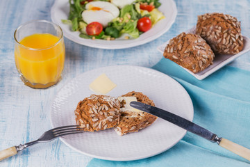 Poached egg with green salad, tomatoes, wholemeal bread and orange juice