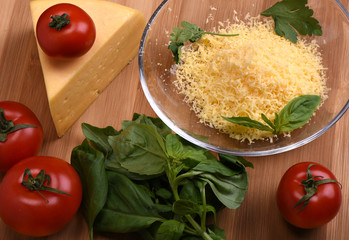 Tomato with basil, a piece of cheese and grated cheese