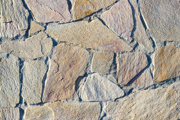 Fragment of a wall made of stone. Stone wall.