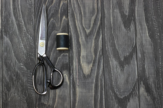 On A Black Wooden Stench, Close-up, Scissors Spool Of Thread With A Needle.