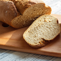 On a wooden background rye bread sliced close-up.