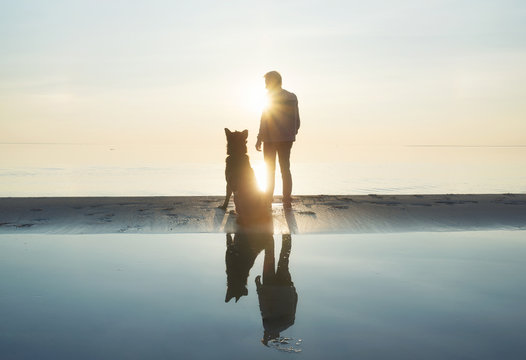 Men with dog friend on the beach. Concept and idea
