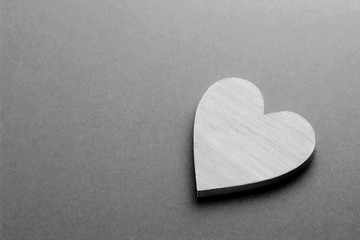 White wooden heart on black and white cardboard background.