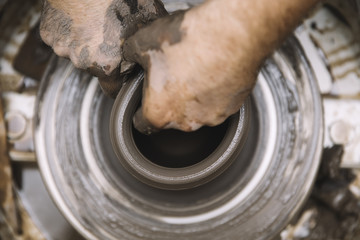 Artist makes clay pottery on a spin wheel