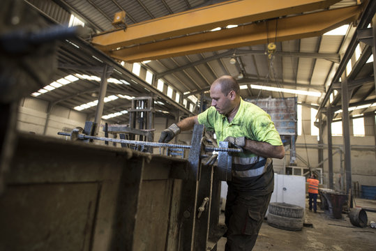 Man measuring and hammering concrete structure for create a construction piece