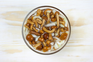 Marinated mushrooms on a wooden background