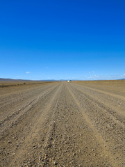 Fototapeta na wymiar Empty Desert Gravel Road. Blue Sky. Hot Weather. Landscape Without People. Desert View. The Wilds. 
