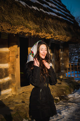 Happy girl stands in the courtyard near a wooden house