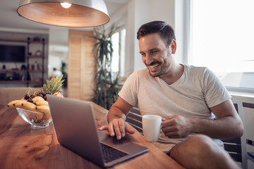 Cheerful  man paying bills at home.E-banking.